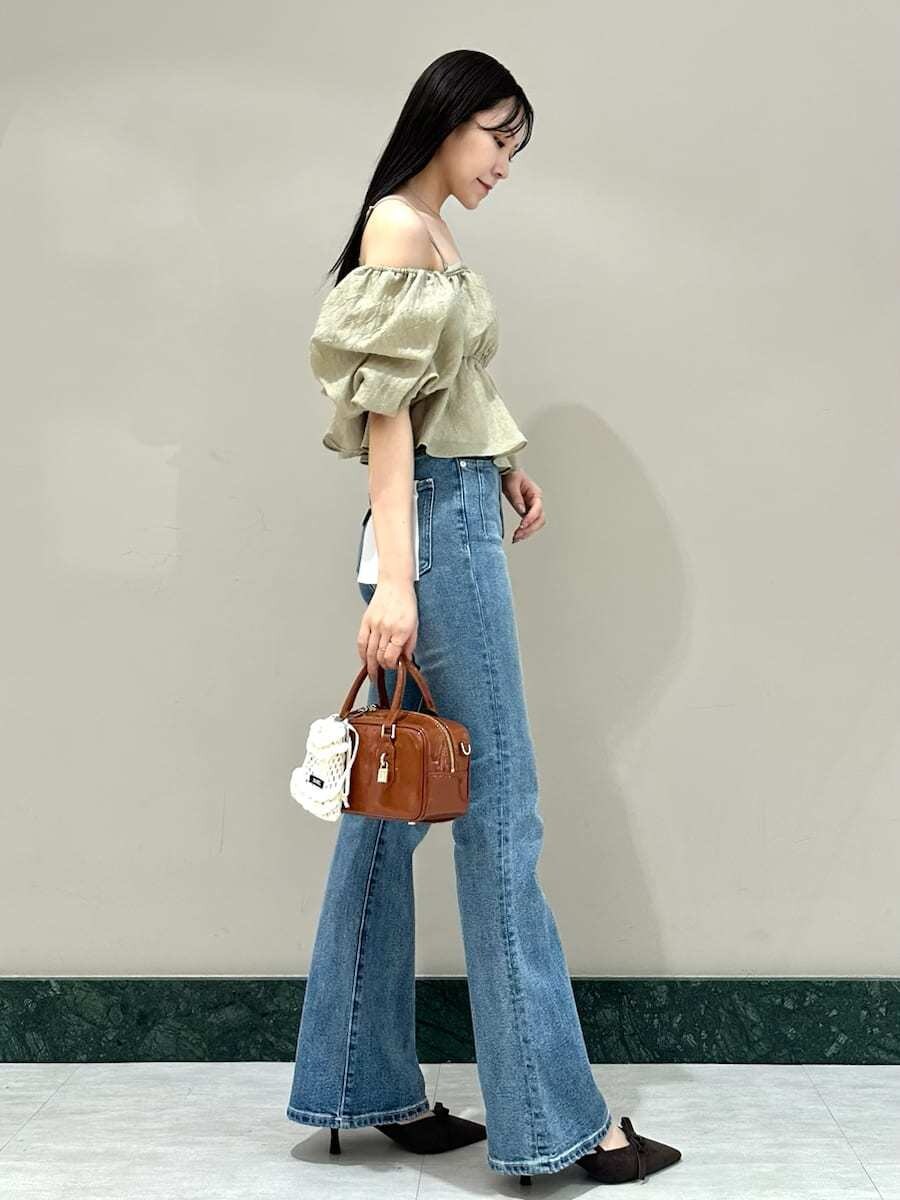 グリーン系のシャツ/ブラウス、ブルー系のその他パンツ、ブラウン系のボストンバッグを着用したレディースの夏コーディネートの2枚目の写真