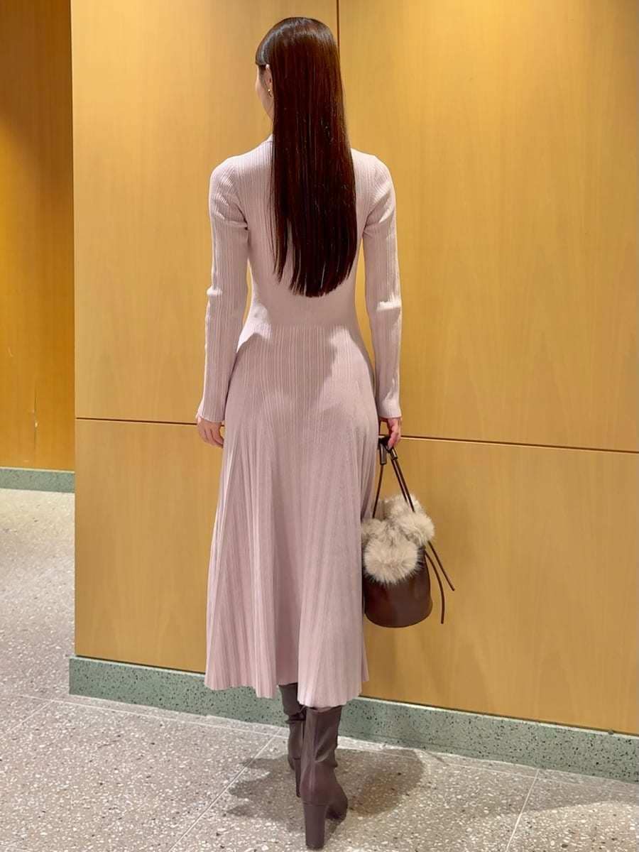 レッド系のブーツ、ブラウン系のステンカラーコート、ピンク系のワンピースを着用したレディースの秋コーディネートの5枚目の写真