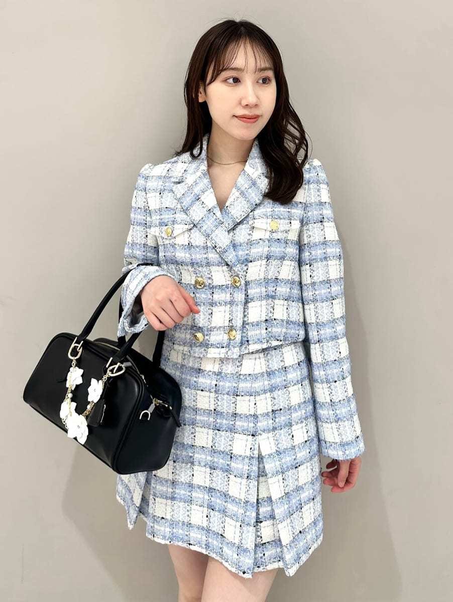 ブルー系のテーラードジャケット、ブルー系のスカート、ブラック系のボストンバッグを着用したレディースの春コーディネートの2枚目の写真