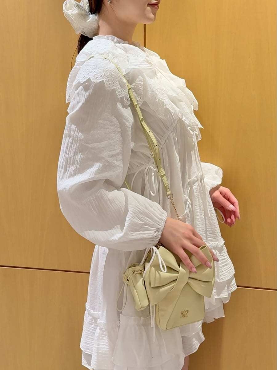 ホワイト系のその他トップス、イエロー系のショルダーバッグを着用したレディースの冬コーディネートの6枚目の写真