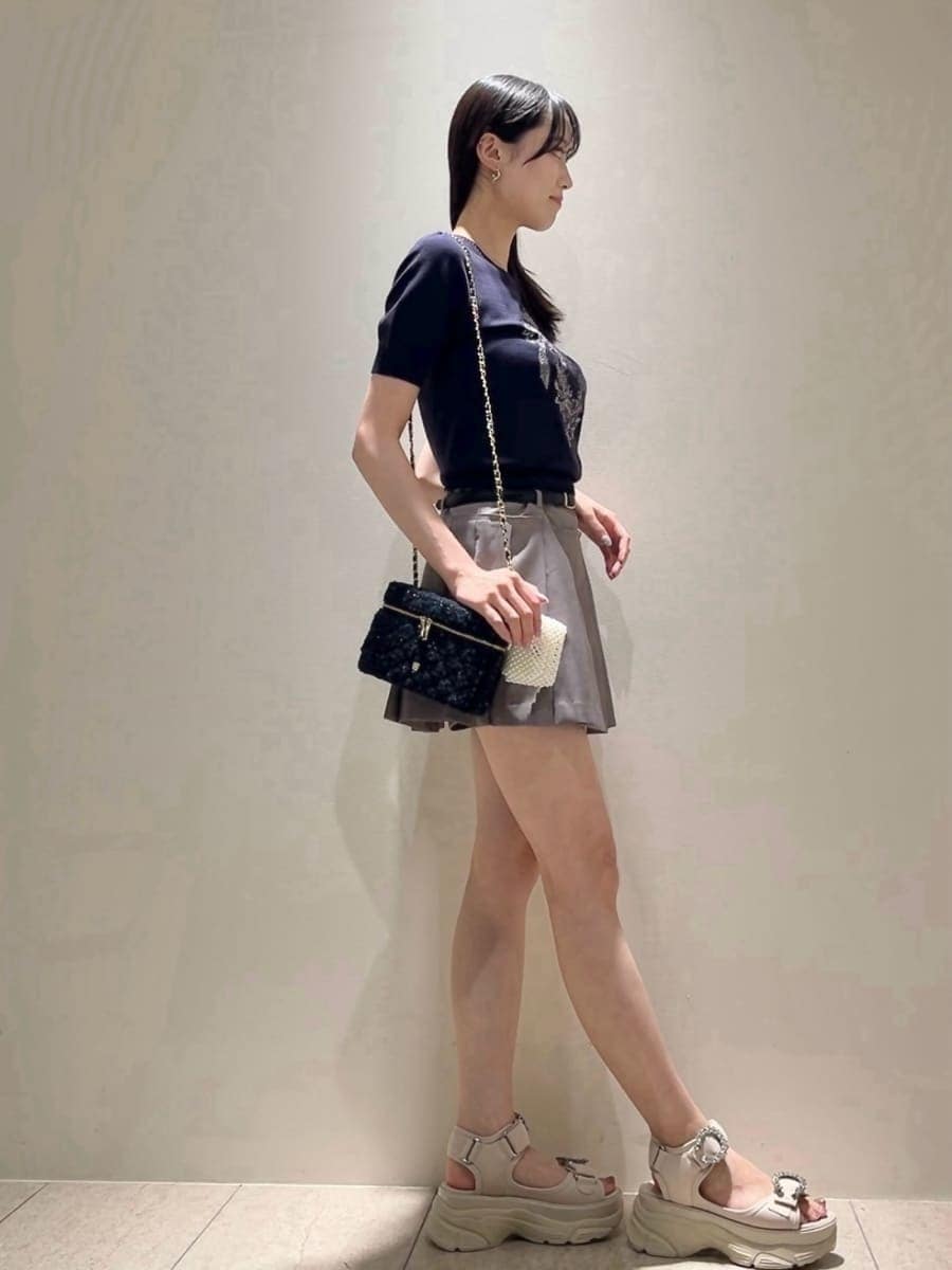 グレー系のその他パンツ、ブルー系のニット/セーター、ベージュ系のサンダルを着用したレディースの夏コーディネートの3枚目の写真