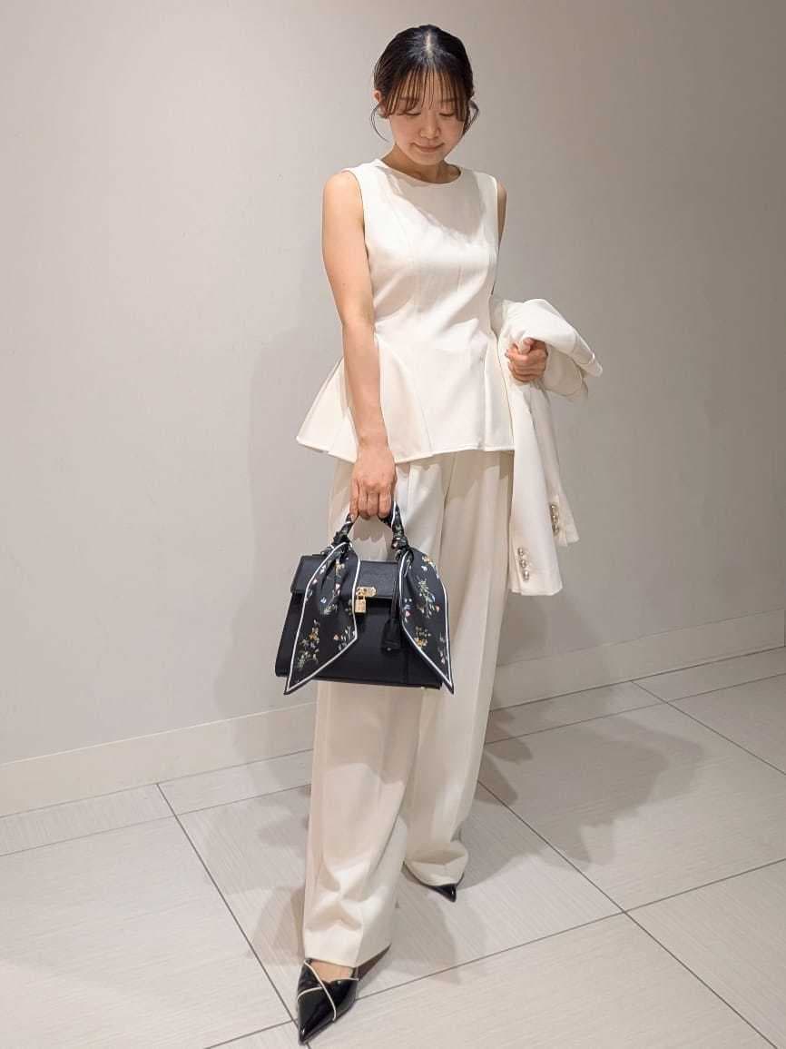 ホワイト系のテーラードジャケット、ホワイト系のワンピース、ブラック系のパンプスを着用したレディースの春コーディネートの5枚目の写真