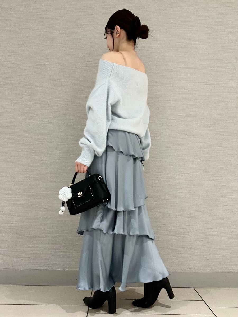 ブルー系のニット/セーター、ブルー系のスカート、ブラック系のブーツを着用したレディースの秋コーディネートの3枚目の写真