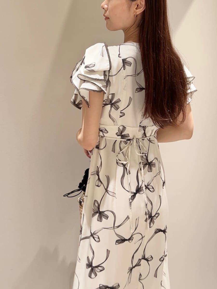 ホワイト系のワンピース、ブラック系のかごバッグ、ホワイト系のサンダルを着用したレディースの夏コーディネートの5枚目の写真