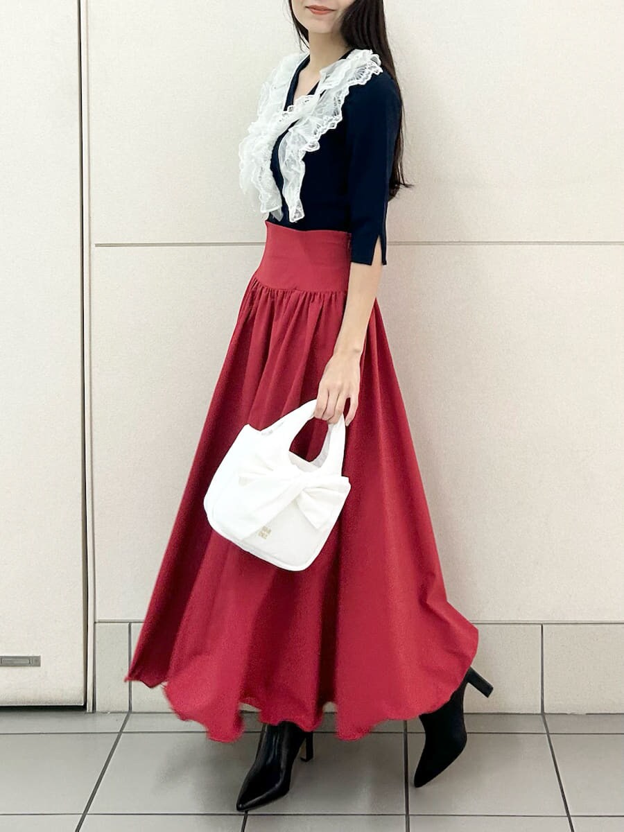 ブラック系のブーツ、ブルー系のニット/セーター、レッド系のスカートを着用したレディースの冬コーディネートの2枚目の写真