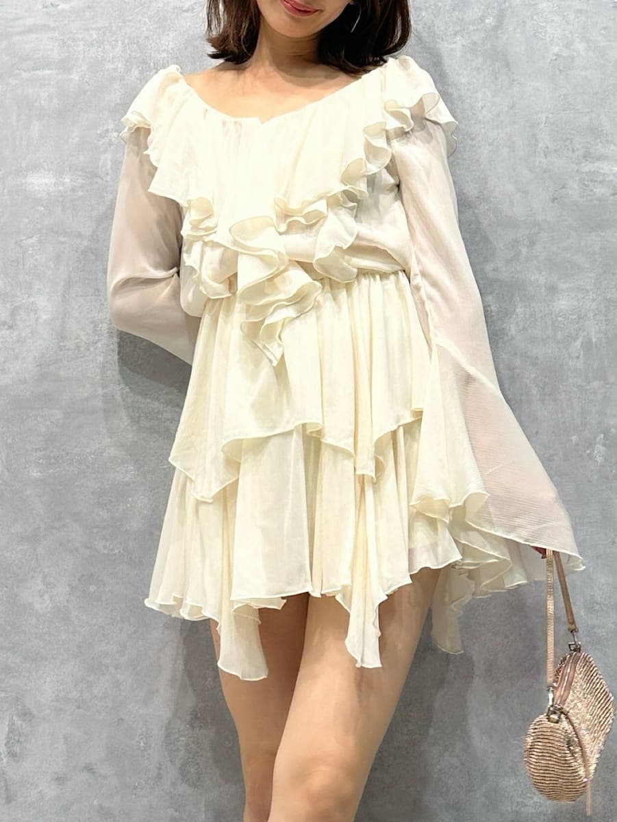 グレー系のステンカラーコート、ホワイト系のワンピースを着用したレディースの秋コーディネートの9枚目の写真