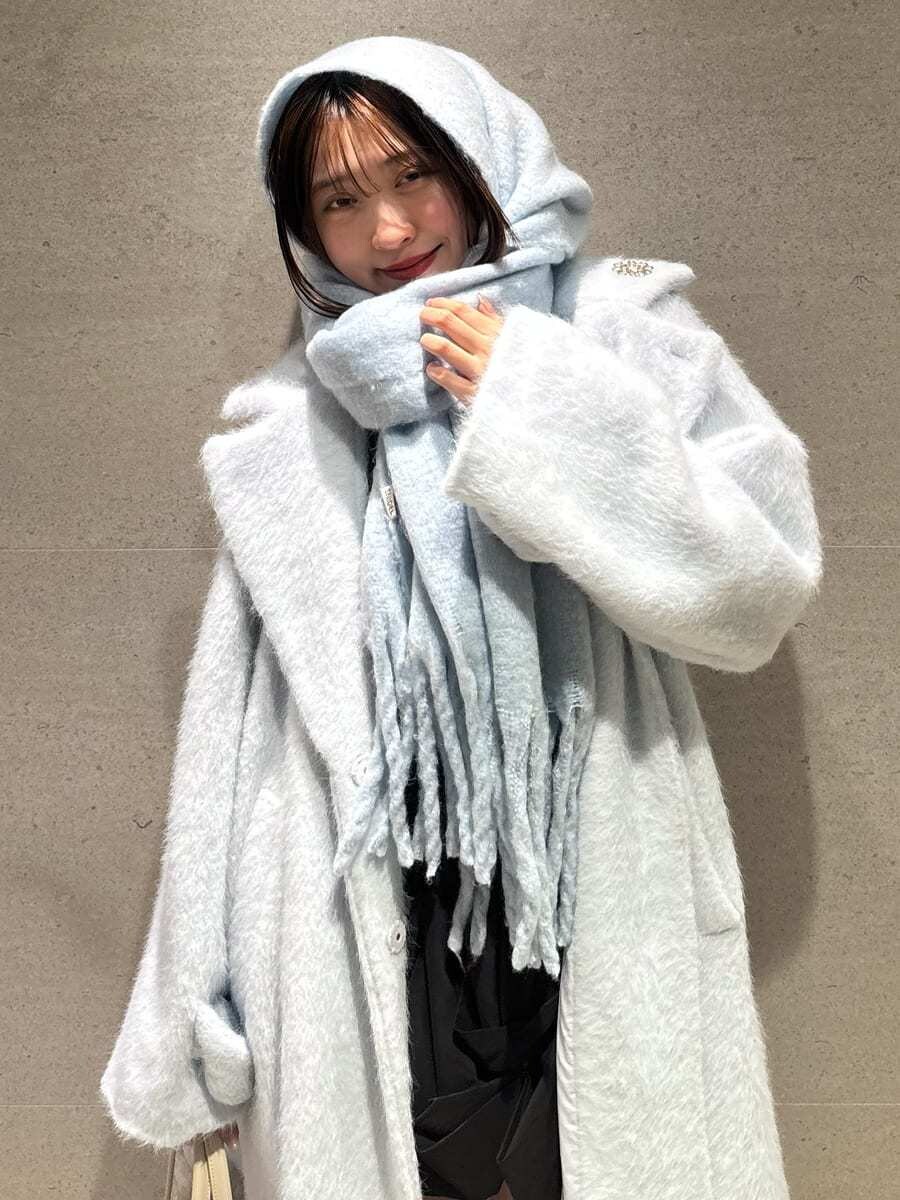 ブラック系のブーツ、ブルー系のチェスターコート、ブラック系のその他パンツを着用したレディースの冬コーディネートの7枚目の写真