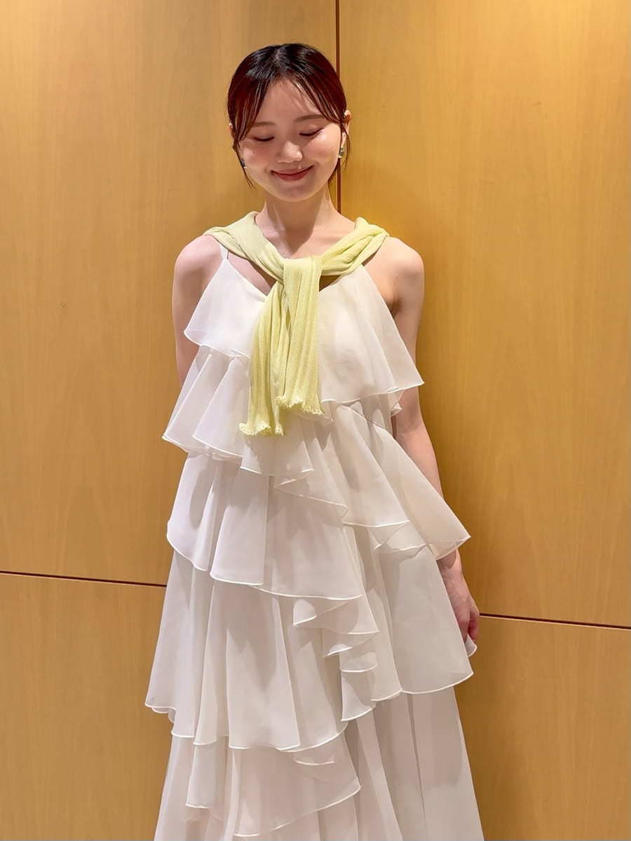 ブラウン系のかごバッグ、イエロー系のカーディガン/ボレロ、ホワイト系のドレスを着用したレディースの夏コーディネートの4枚目の写真