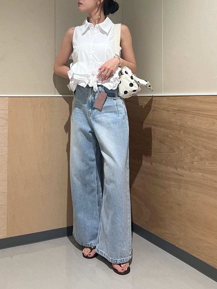ブルー系のデニムパンツ、ホワイト系のシャツ/ブラウス、ホワイト系のショルダーバッグを着用したレディースの夏コーディネートの4枚目の写真
