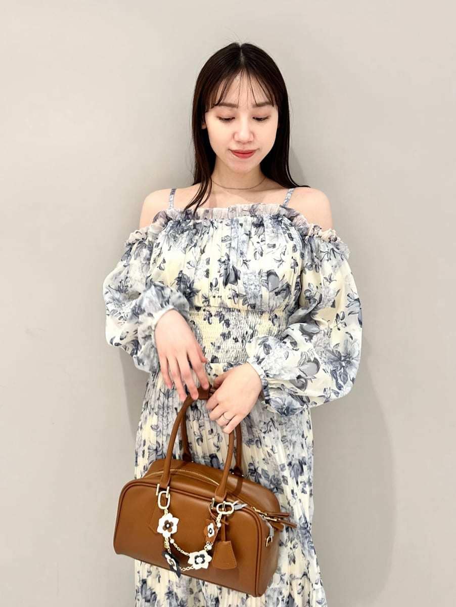 イエロー系のワンピース、イエロー系のボストンバッグ、ブラウン系のキーケース/キーアクセサリーを着用したレディースの冬コーディネートの2枚目の写真