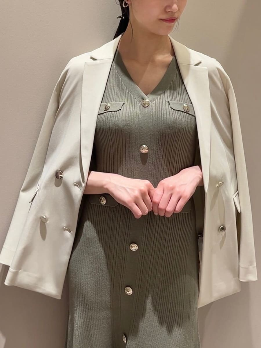 ベージュ系のテーラードジャケット、グリーン系のワンピース、ホワイト系のショルダーバッグを着用したレディースの夏コーディネートの2枚目の写真