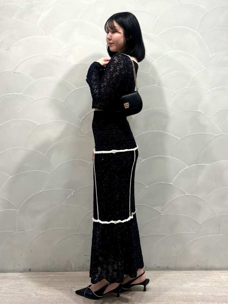 ブルー系のスカート、ブルー系のニット/セーター、ブラック系のパンプスを着用したレディースの冬コーディネートの2枚目の写真