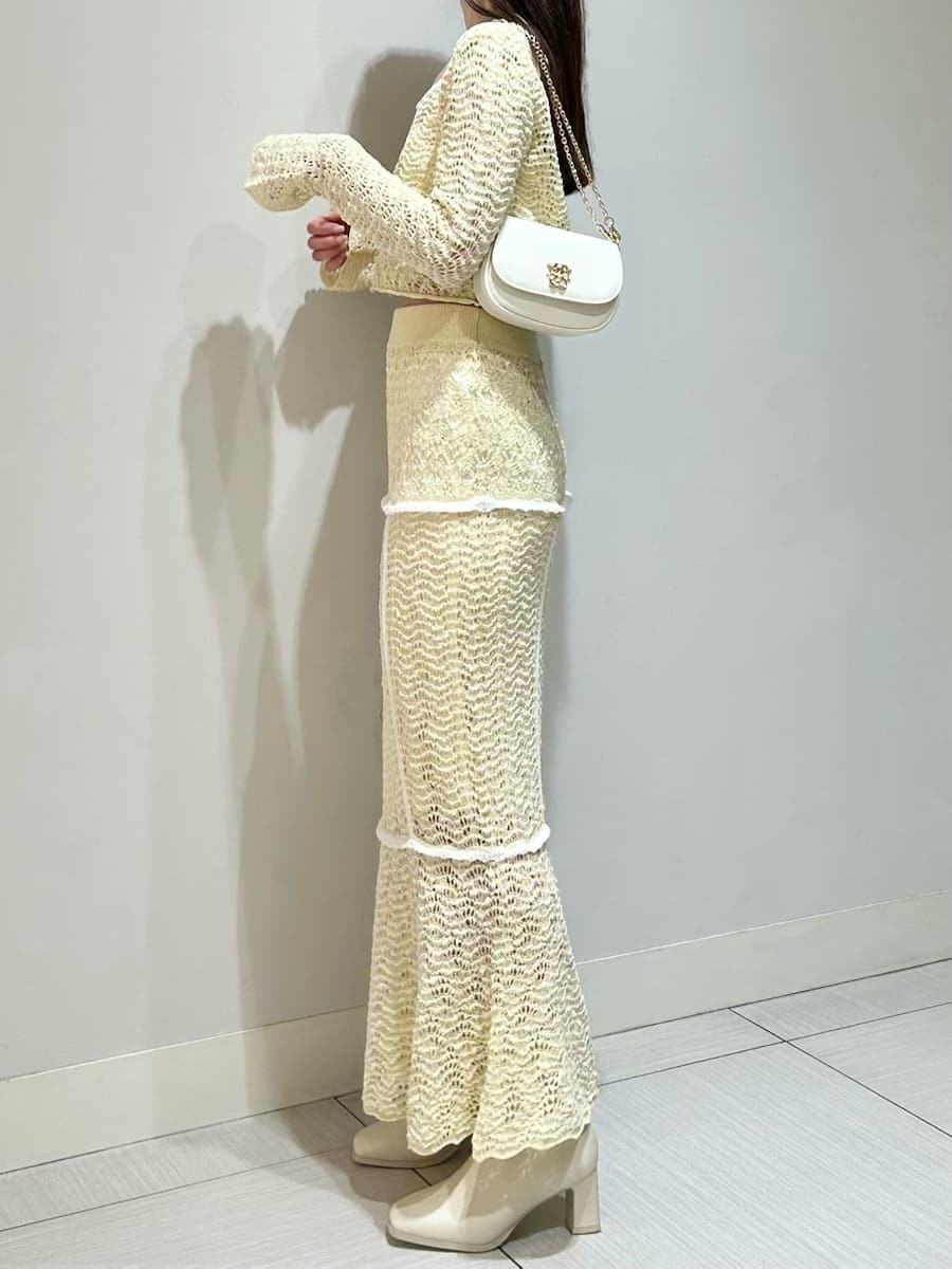 イエロー系のスカート、イエロー系のニット/セーター、ホワイト系のショルダーバッグを着用したレディースの春コーディネートの2枚目の写真