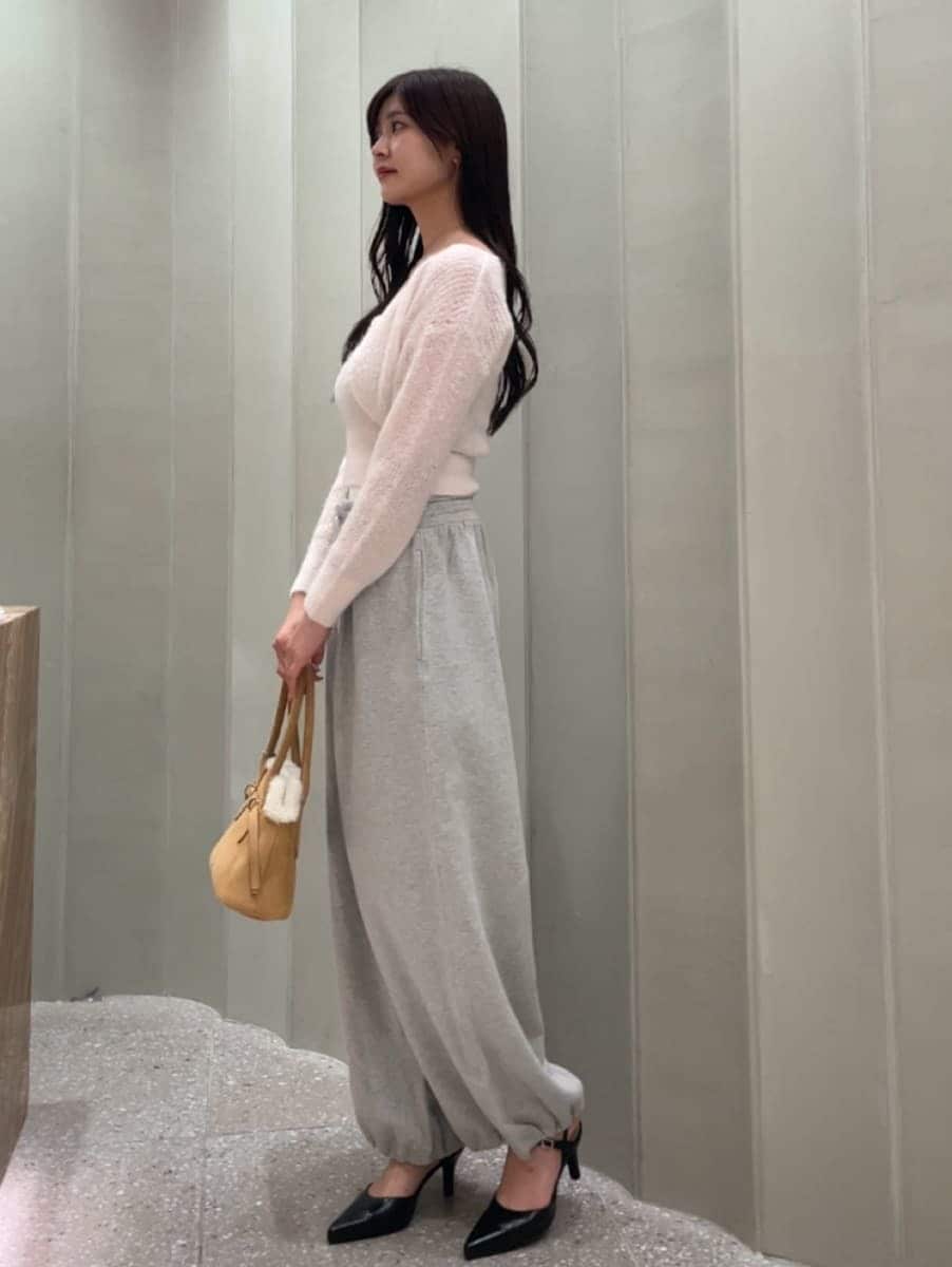 グレー系のその他パンツ、ピンク系のカーディガン/ボレロ、ブラック系のパンプスを着用したレディースの秋コーディネートの5枚目の写真