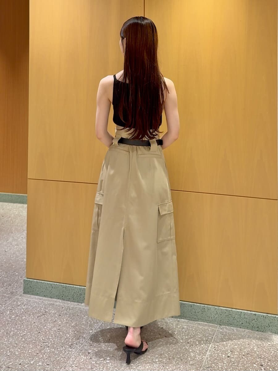 ベージュ系のスカート、ブラック系のニット/セーター、ブラウン系のトートバッグを着用したレディースの夏コーディネートの3枚目の写真