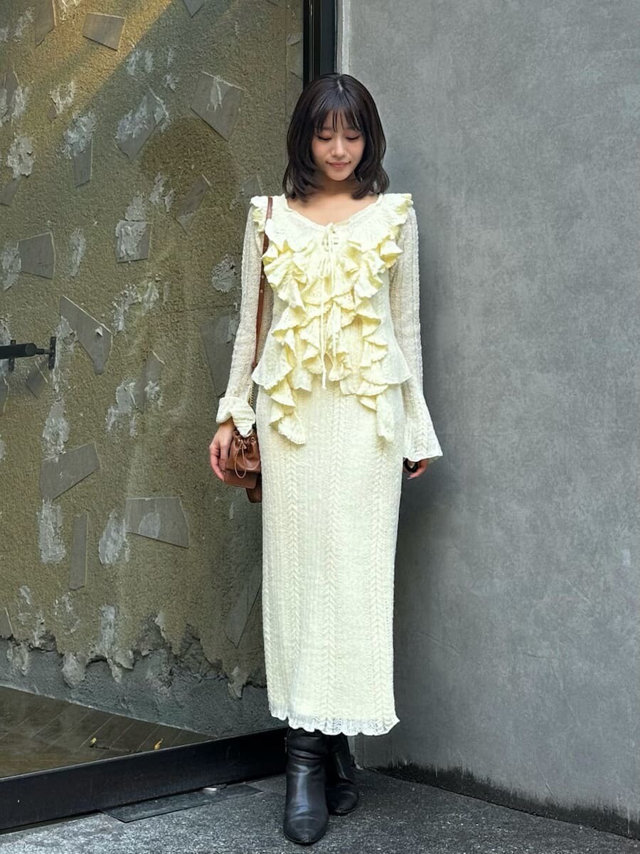 グレー系のブーツ、イエロー系のスカート、イエロー系のニット/セーターを着用したレディースの秋コーディネートの3枚目の写真