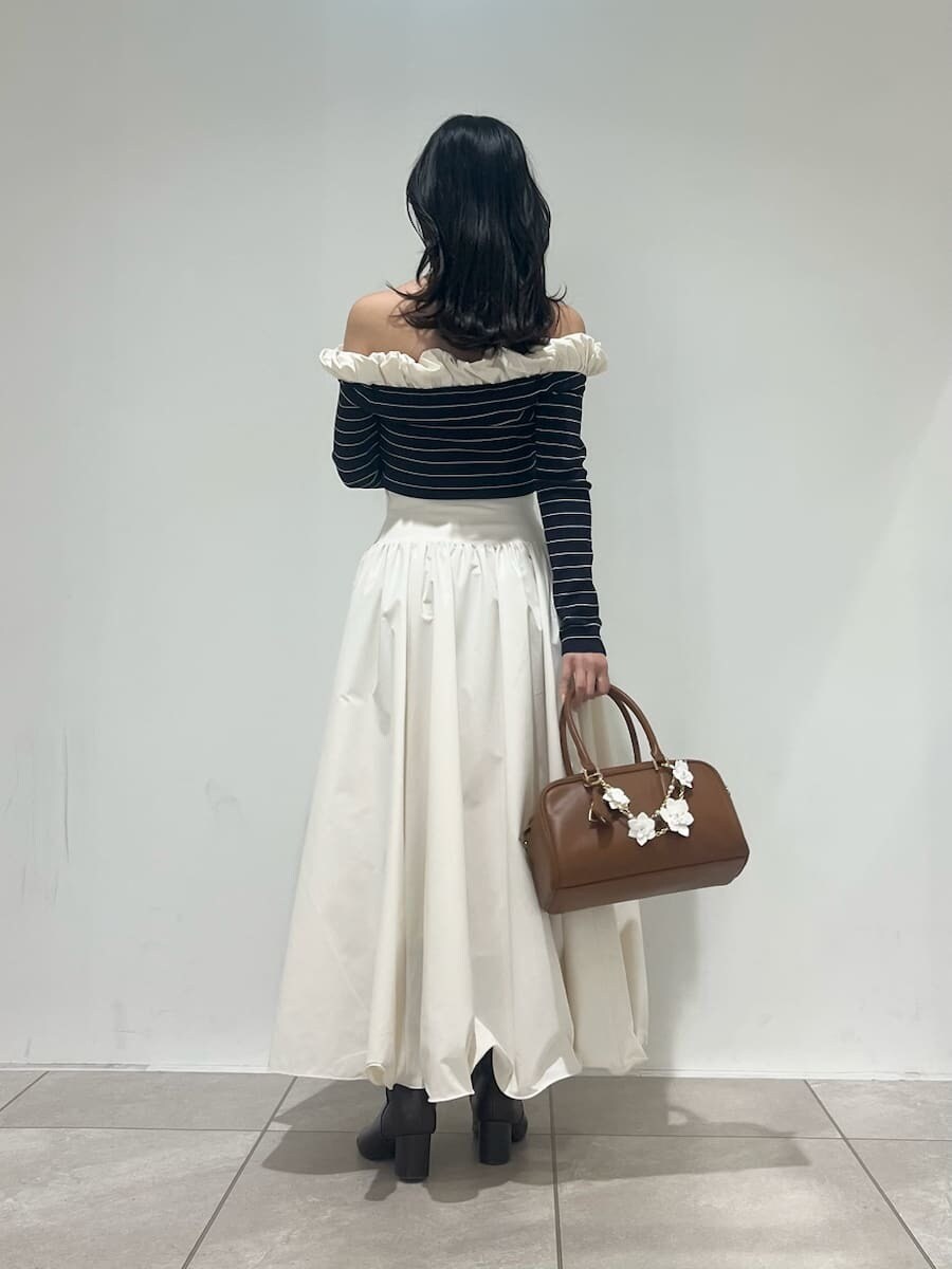 ブラウン系のブーツ、ホワイト系のスカート、その他のニット/セーターを着用したレディースの冬コーディネートの3枚目の写真