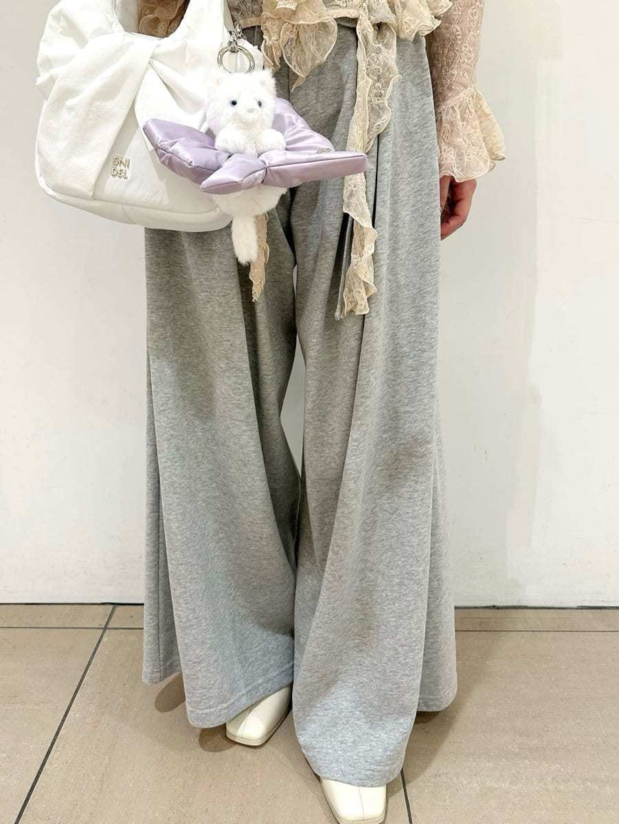 グレー系のその他パンツ、ピンク系のTシャツ/カットソー、ホワイト系のキーケース/キーアクセサリーを着用したレディースの冬コーディネートの4枚目の写真