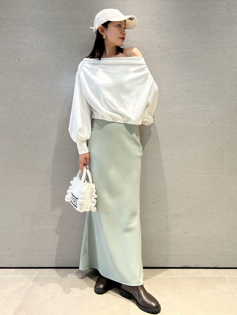 グリーン系のスカート、ホワイト系のスウェット、ホワイト系のショルダーバッグを着用したレディースの春コーディネートの3枚目の写真