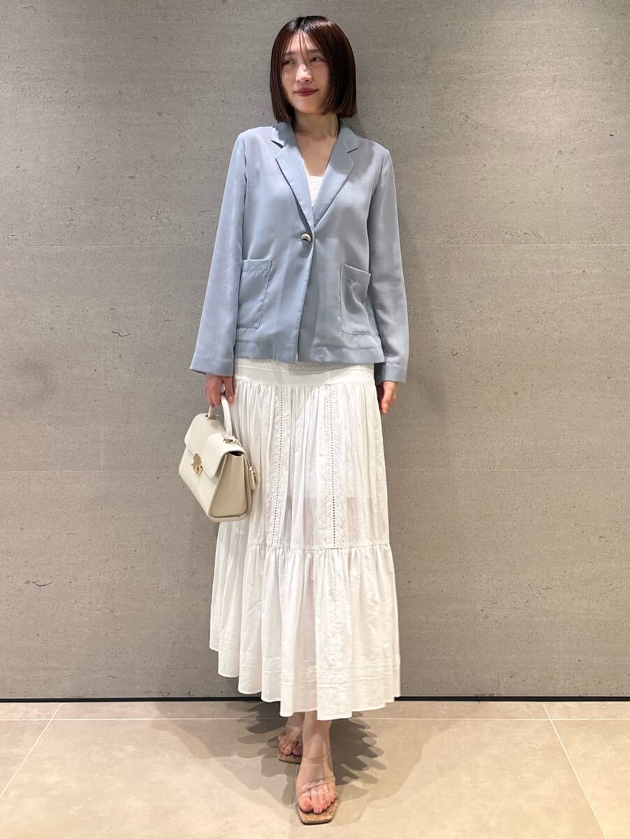 ブルー系のテーラードジャケット、ホワイト系のスカート、ホワイト系のショルダーバッグを着用したレディースの夏コーディネートの2枚目の写真
