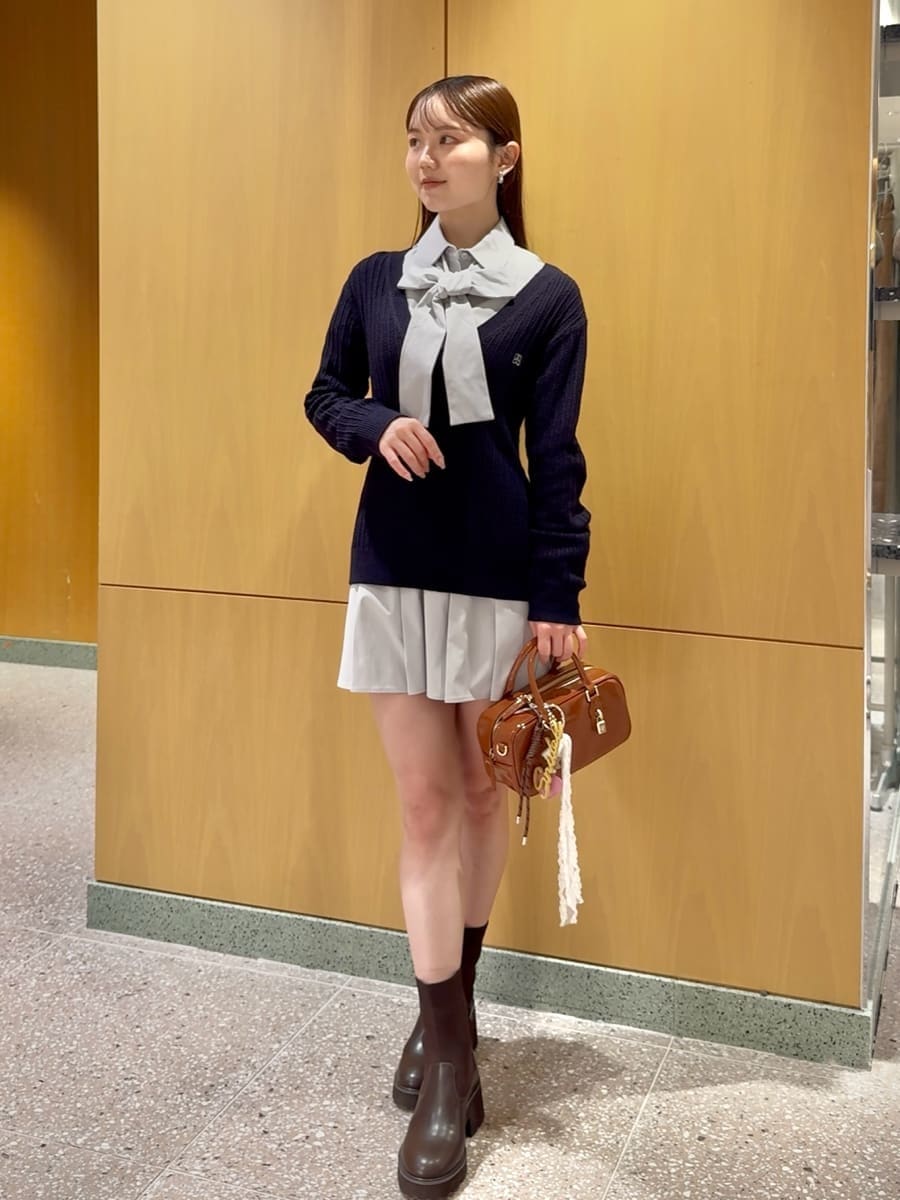 ベージュ系のステンカラーコート、ブルー系のその他トップス、ブラウン系のボストンバッグを着用したレディースの秋コーディネートの6枚目の写真