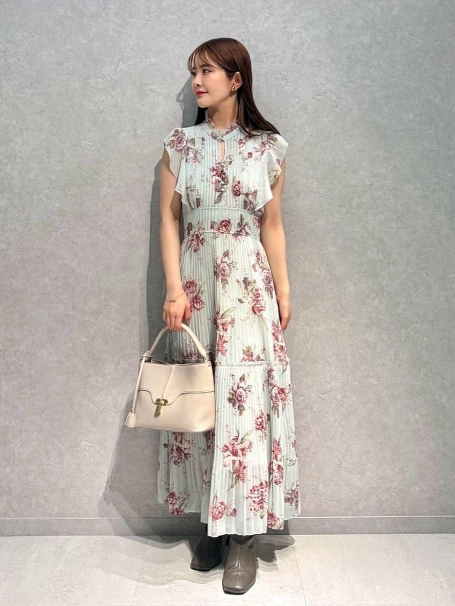 ホワイト系のテーラードジャケット、グリーン系のワンピース、ベージュ系のハンドバッグを着用したレディースの春コーディネートの7枚目の写真