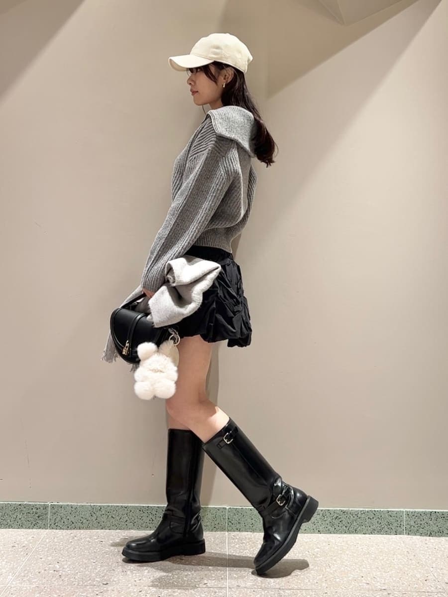 グレー系のニット/セーター、ブラック系のブーツ、ブラック系のハンドバッグを着用したレディースの冬コーディネートの5枚目の写真