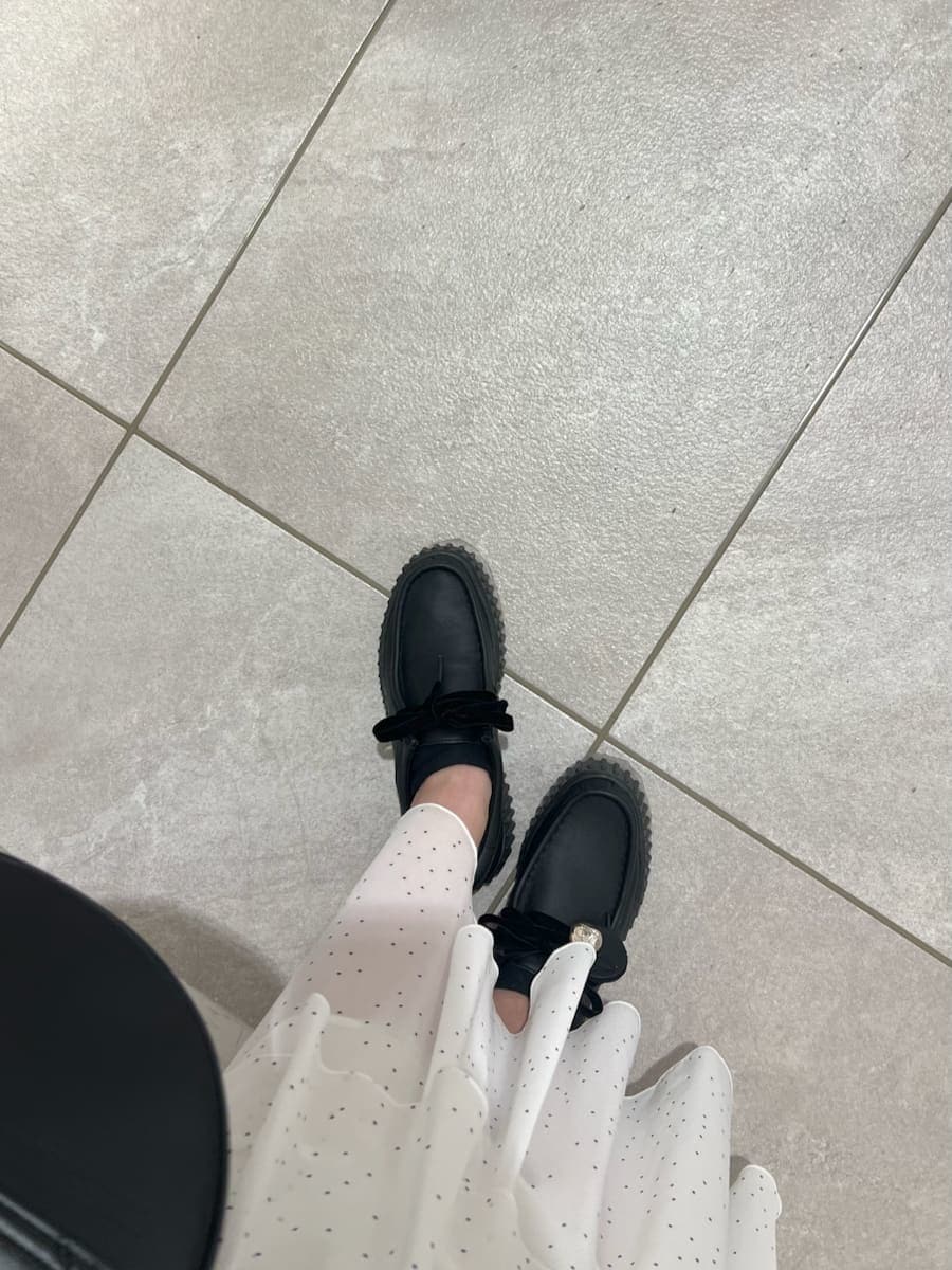 ブラック系のハンドバッグ、ブラック系のその他シューズ、その他のワンピースを着用したレディースの冬コーディネートの10枚目の写真