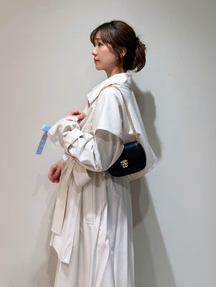 ホワイト系のトレンチコート、グレー系のスカート、ブルー系のニット/セーターを着用したレディースの冬コーディネートの4枚目の写真