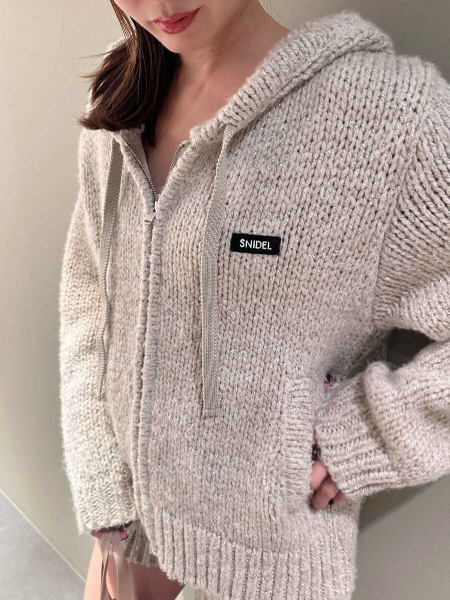 ホワイト系のその他パンツ、ホワイト系のニット/セーター、ベージュ系のハンドバッグを着用したレディースの夏コーディネートの2枚目の写真