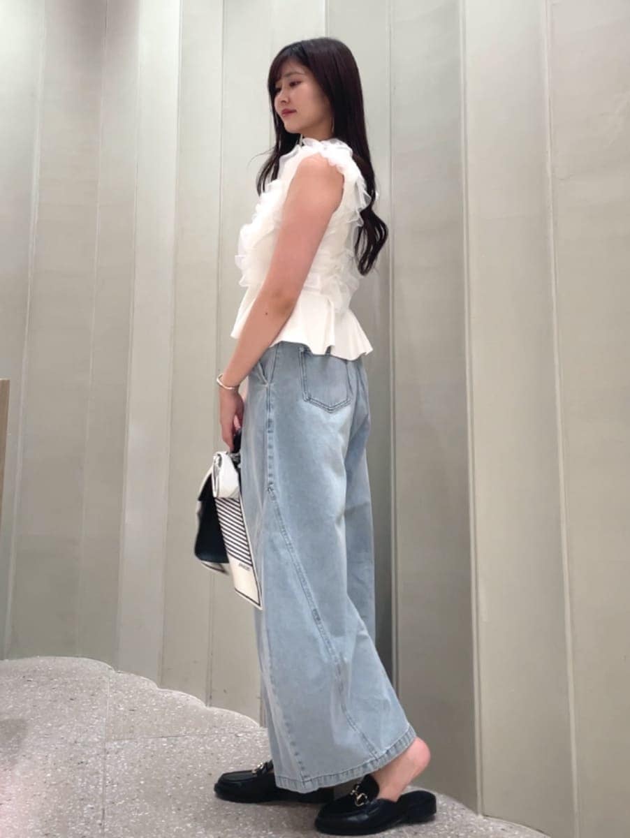 ブラック系のハンドバッグ、ブルー系のデニムパンツ、ホワイト系のニット/セーターを着用したレディースの夏コーディネートの5枚目の写真