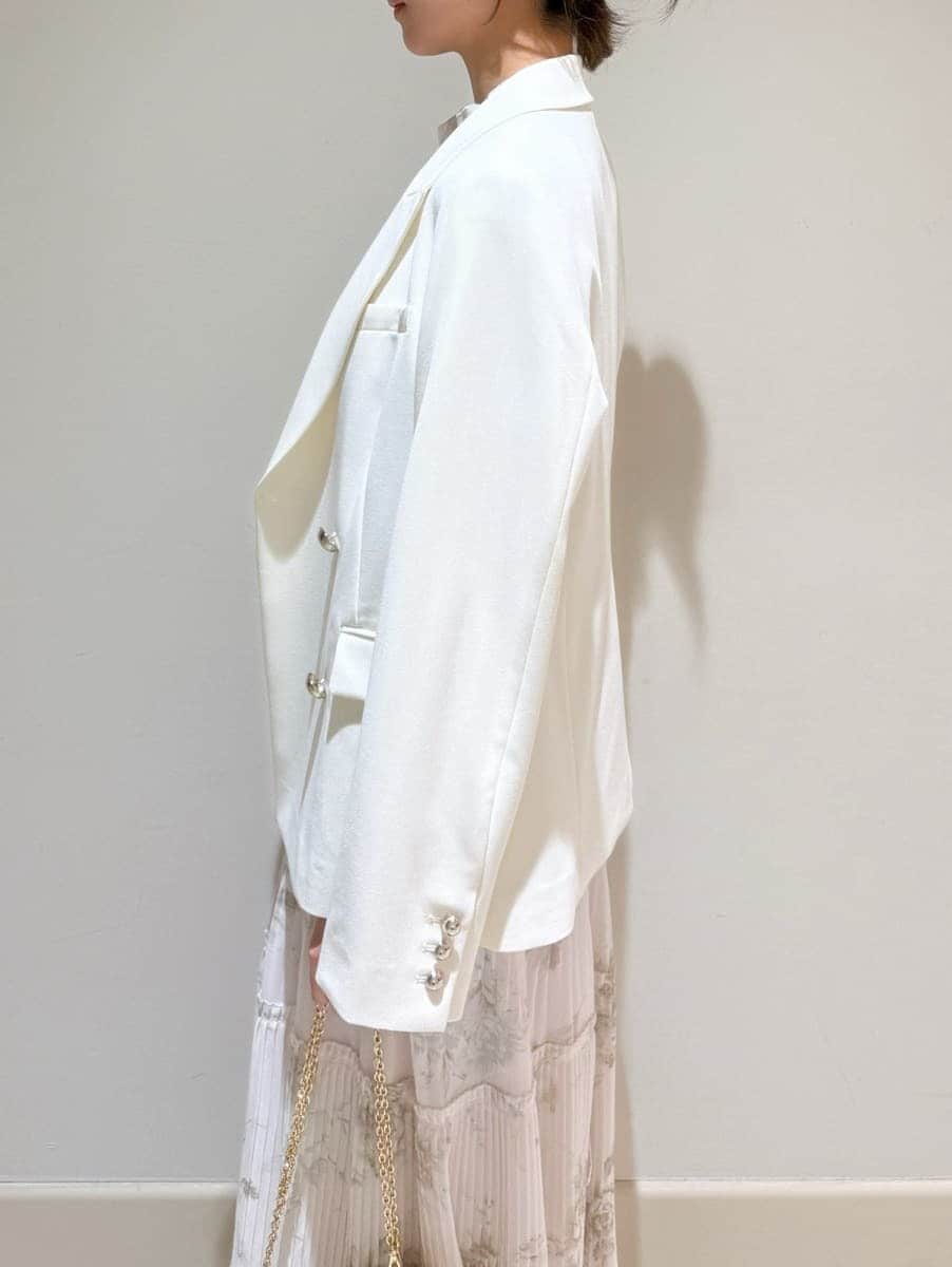 ホワイト系のテーラードジャケット、ピンク系のワンピース、ホワイト系のショルダーバッグを着用したレディースの春コーディネートの6枚目の写真