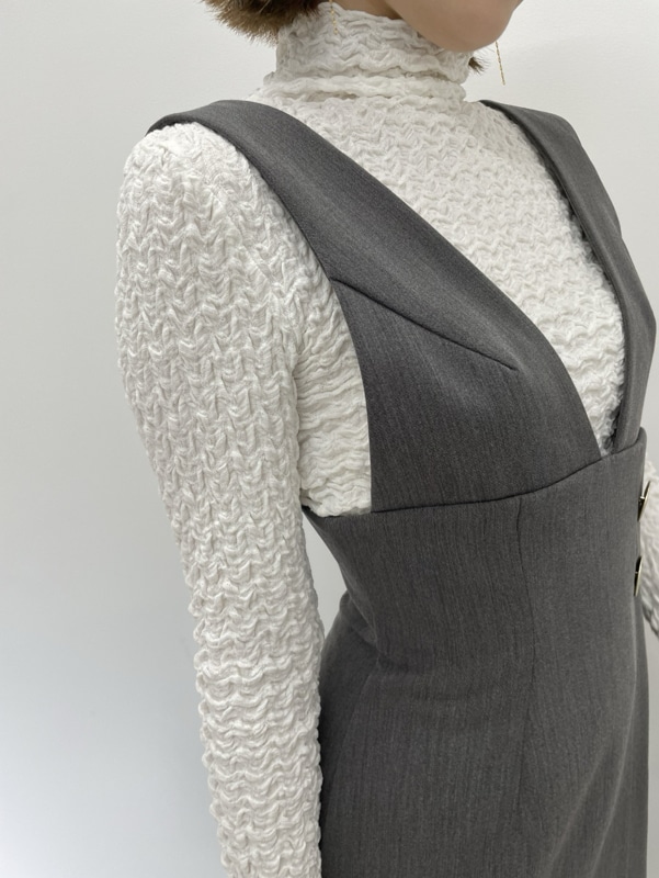 グレー系のワンピース、ブラック系のショルダーバッグ、ブラック系のブーツを着用したレディースの秋コーディネートの4枚目の写真