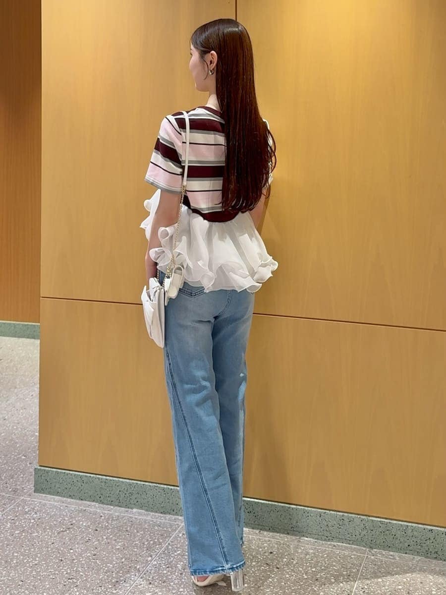 ブルー系のデニムパンツ、ピンク系のTシャツ/カットソー、ホワイト系のショルダーバッグを着用したレディースの春コーディネートの3枚目の写真