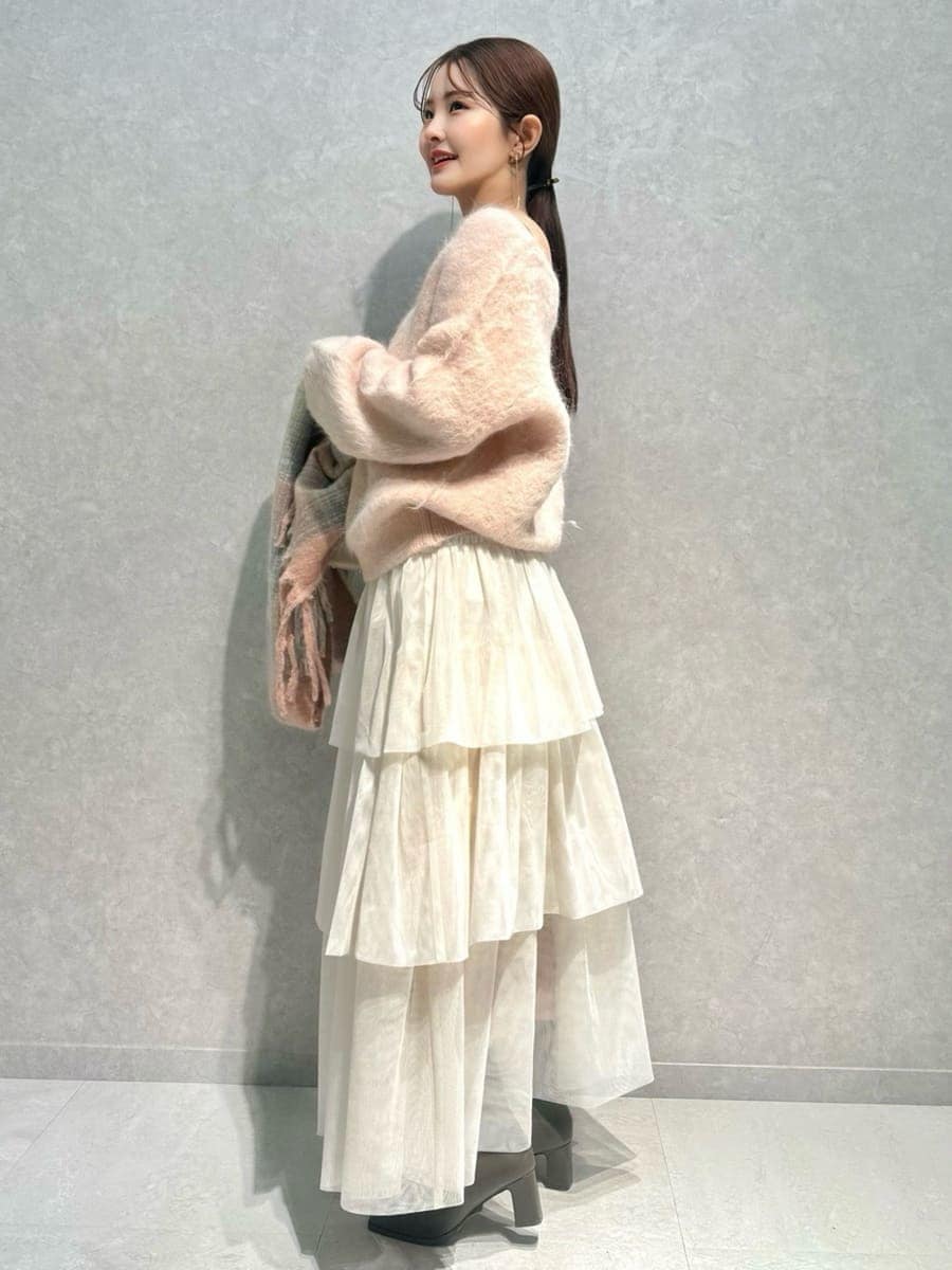 ピンク系のニット/セーター、ホワイト系のチェスターコート、ホワイト系のスカートを着用したレディースの冬コーディネートの6枚目の写真