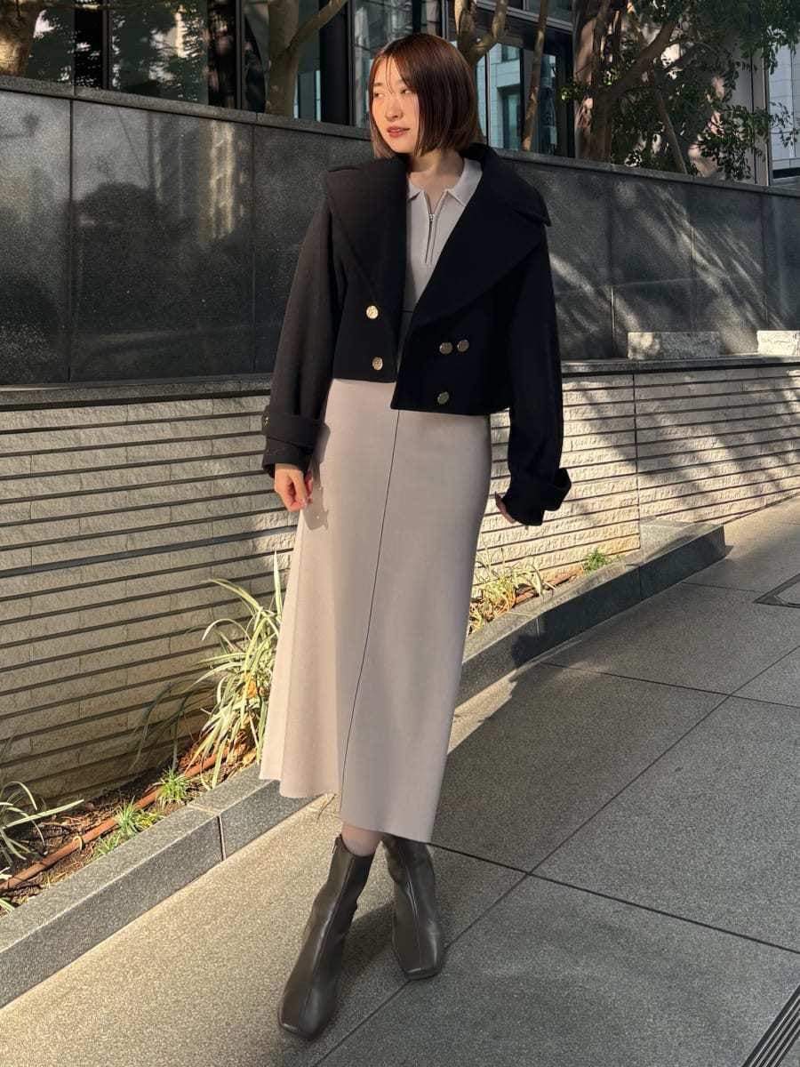 ブラック系のピーコート、ホワイト系のワンピース、ホワイト系のショルダーバッグを着用したレディースの冬コーディネートの2枚目の写真