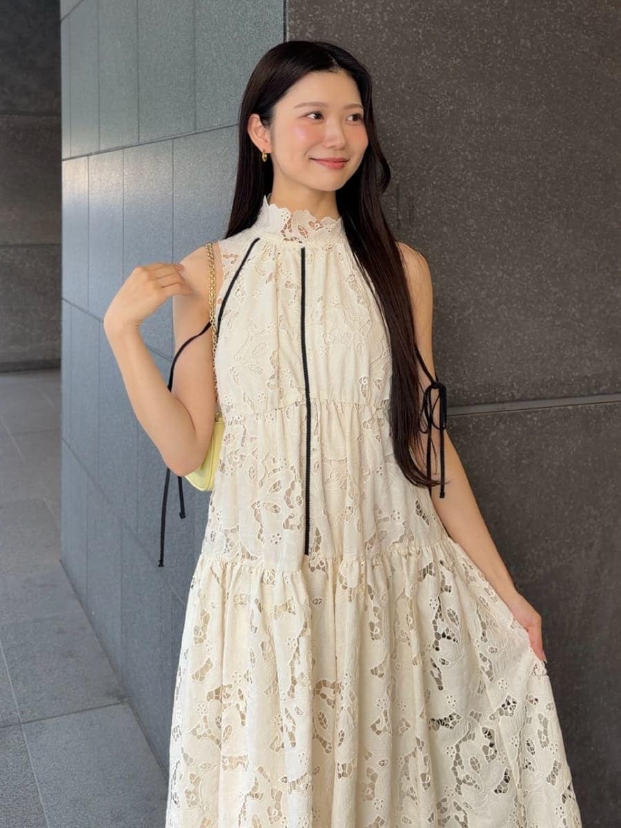 イエロー系のショルダーバッグ、ホワイト系のワンピース、ブラウン系のサンダルを着用したレディースの夏コーディネートの6枚目の写真