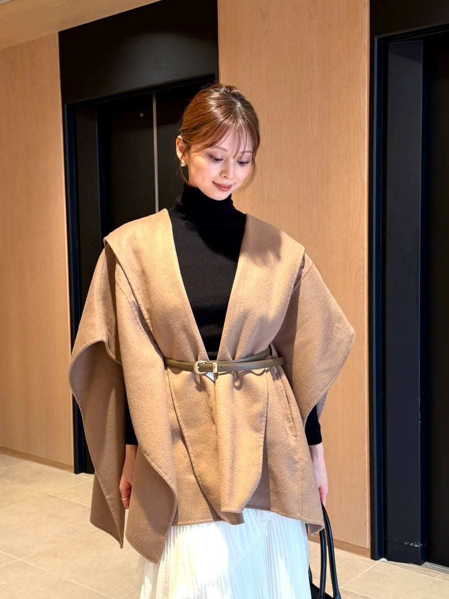 グレー系のブーツ、イエロー系のその他アウター、ホワイト系のスカートを着用したレディースの秋コーディネートの2枚目の写真