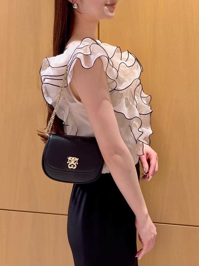 ブラック系のスカート、ベージュ系のシャツ/ブラウス、ブラック系のパンプスを着用したレディースの春コーディネートの6枚目の写真