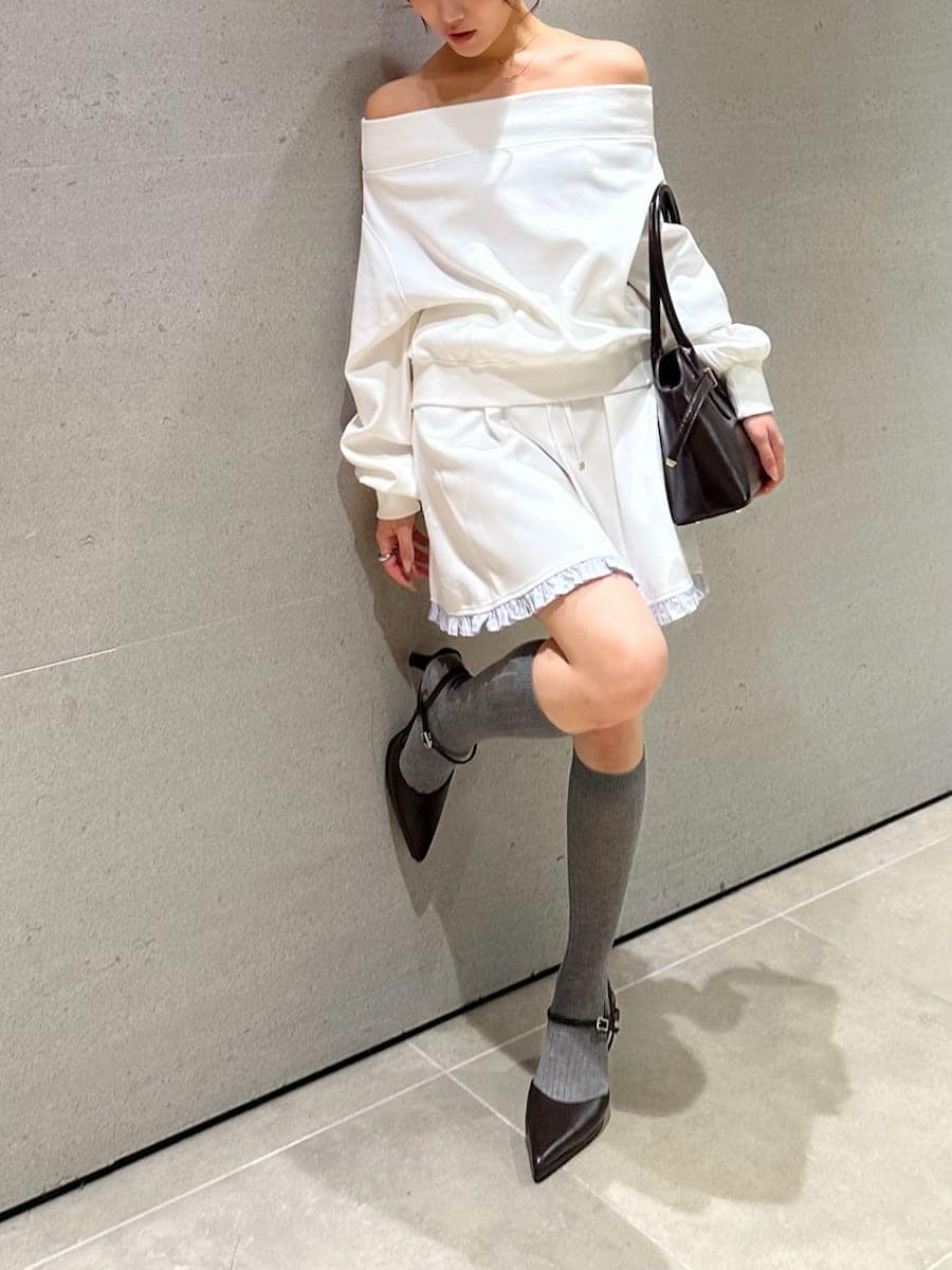ホワイト系のワンピース、ブラウン系のパンプス、ブラウン系のボストンバッグを着用したレディースの秋コーディネートの3枚目の写真