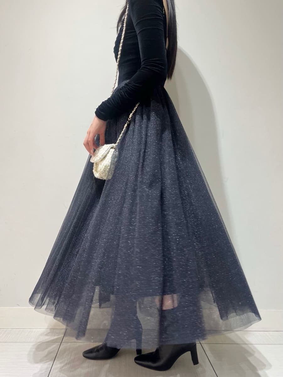 ブラック系のワンピース、ホワイト系のショルダーバッグ、ブラック系のブーツを着用したレディースの夏コーディネートの5枚目の写真