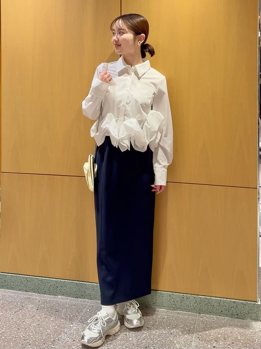 ブルー系のスカート、ホワイト系のシャツ/ブラウス、イエロー系のショルダーバッグを着用したレディースの冬コーディネートの2枚目の写真