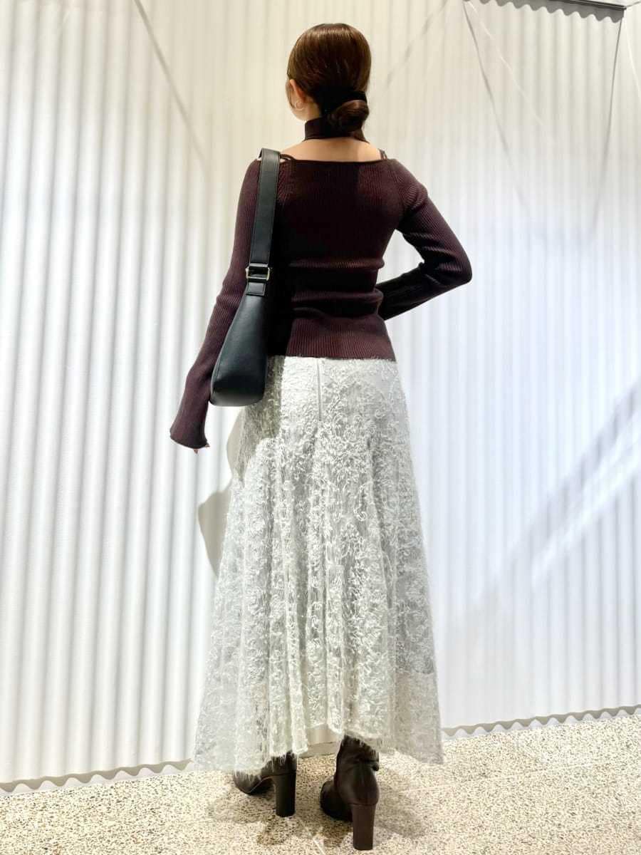 ブラウン系のニット/セーター、グリーン系のスカート、レッド系のブーツを着用したレディースの秋コーディネートの2枚目の写真