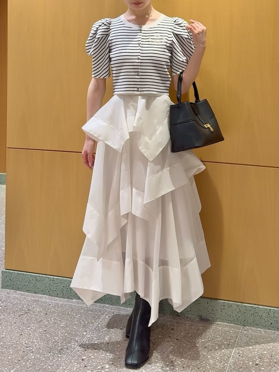 ホワイト系のスカート、その他のカーディガン/ボレロ、ブラック系のハンドバッグを着用したレディースの春コーディネートの5枚目の写真