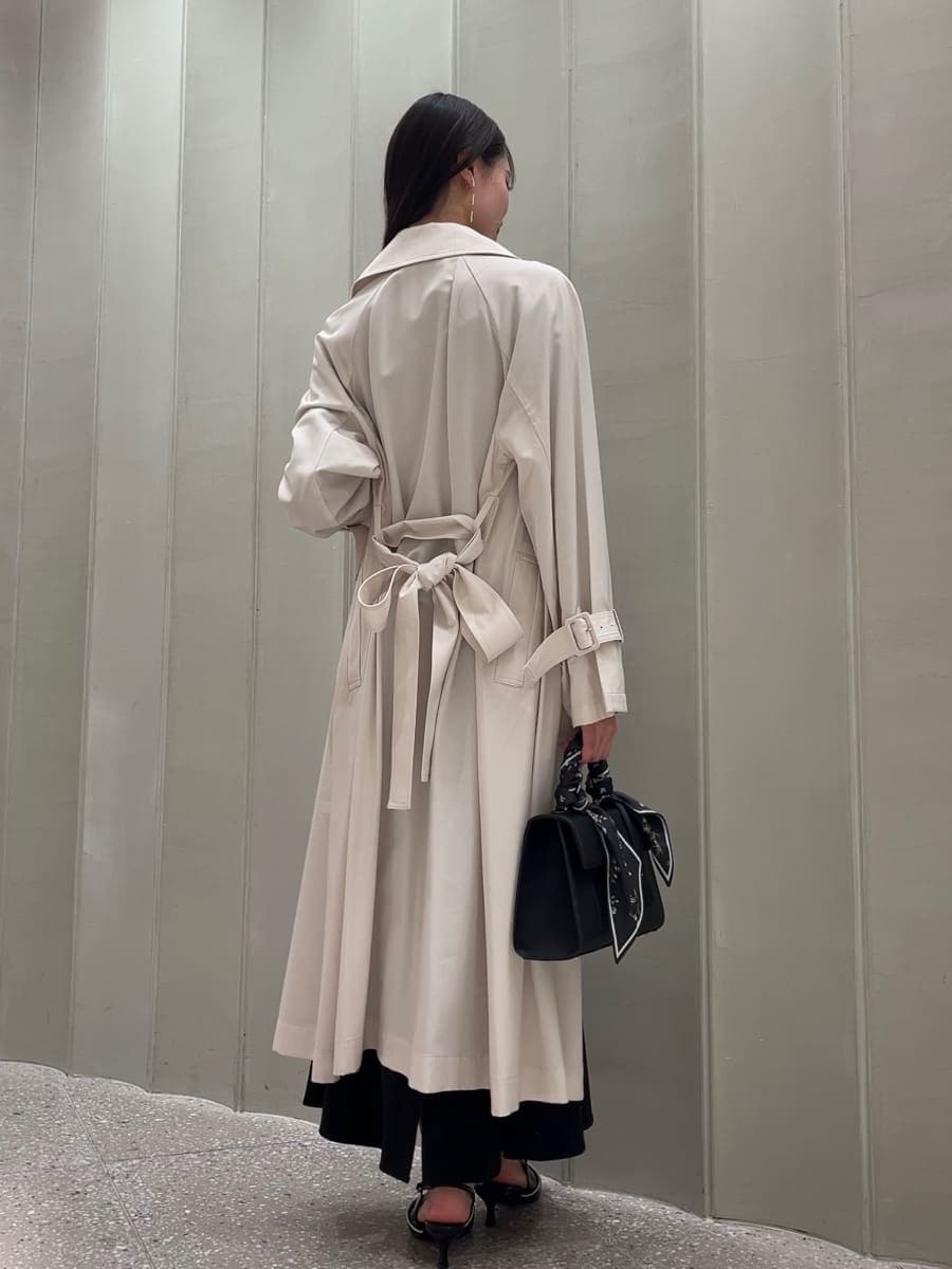 ホワイト系のトレンチコート、ブラック系のスカート、ブラック系のパンプスを着用したレディースの冬コーディネートの5枚目の写真