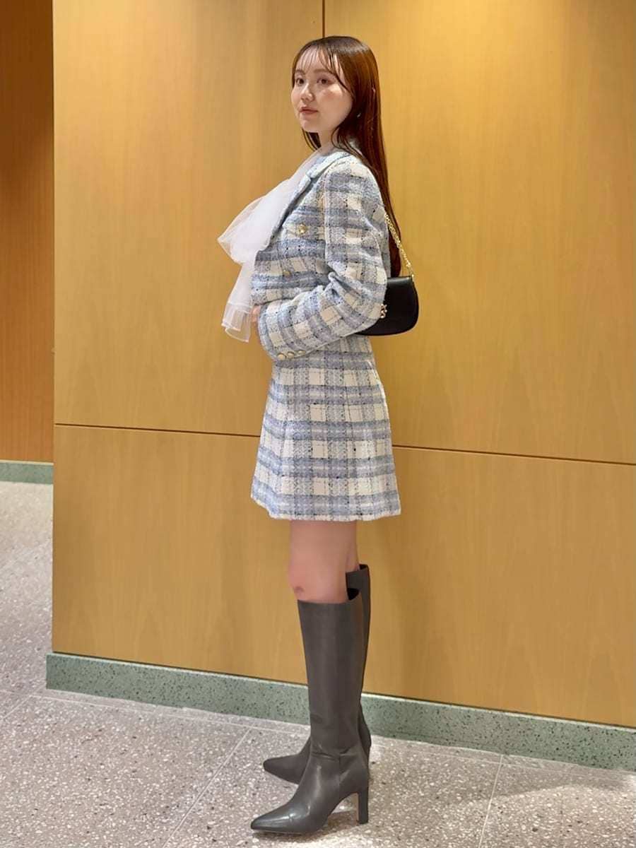 グレー系のブーツ、ブルー系のテーラードジャケット、ブルー系のスカートを着用したレディースの春コーディネートの3枚目の写真