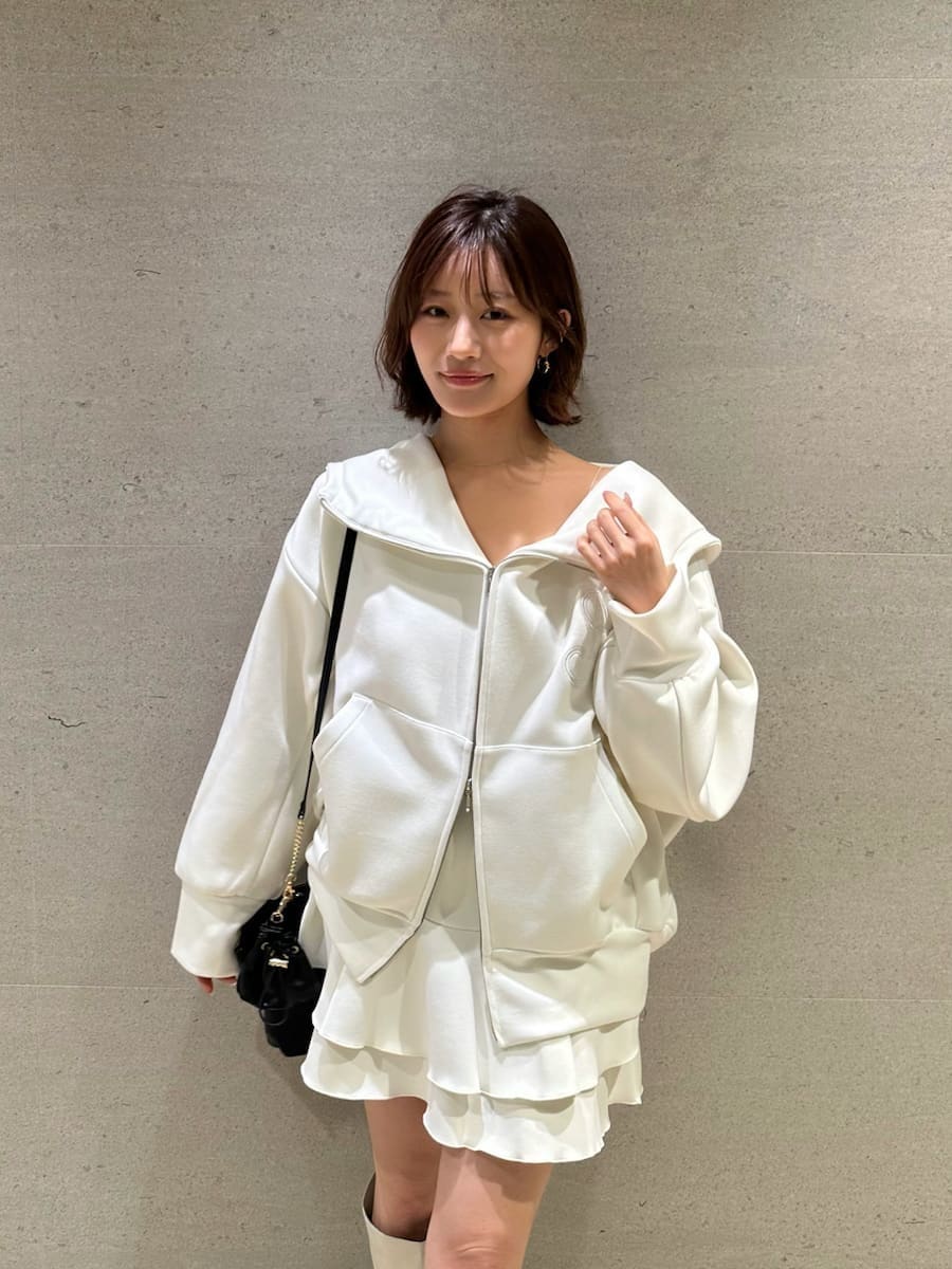 ホワイト系のパーカー、ホワイト系のブーツ、ブラック系のショルダーバッグを着用したレディースの冬コーディネートの8枚目の写真