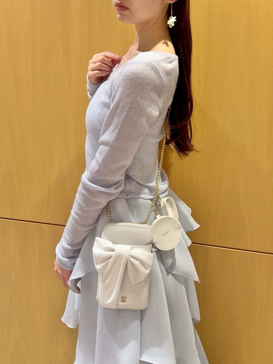 ブルー系のワンピース、ホワイト系のショルダーバッグ、その他のイヤリングを着用したレディースの冬コーディネートの7枚目の写真