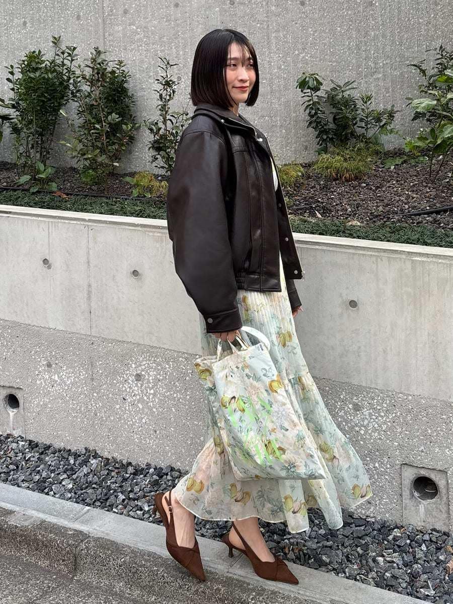 ブラウン系のブルゾン、グリーン系のワンピース、ブラウン系のパンプスを着用したレディースの冬コーディネートの2枚目の写真