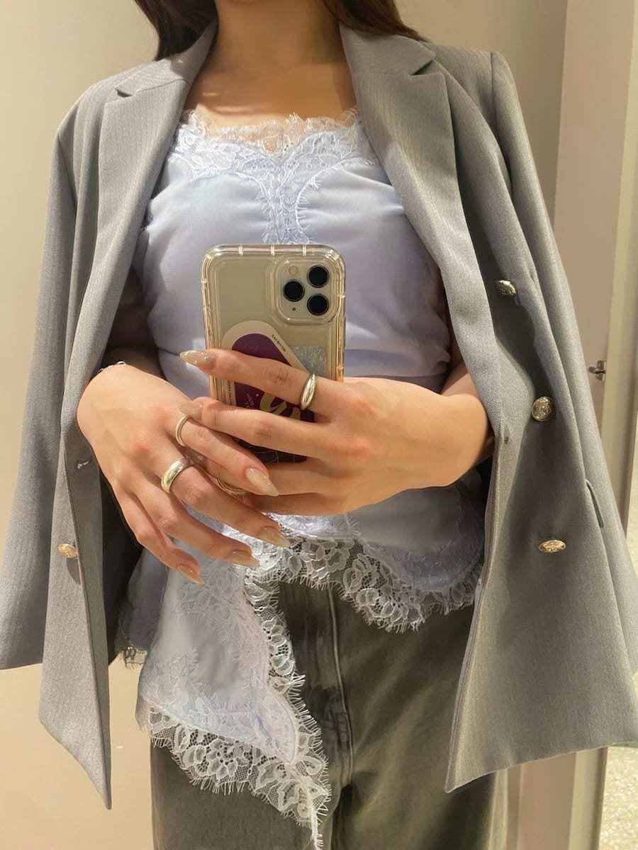 グレー系のテーラードジャケット、グレー系のデニムパンツ、ブルー系のキャミソールを着用したレディースの秋コーディネートの9枚目の写真
